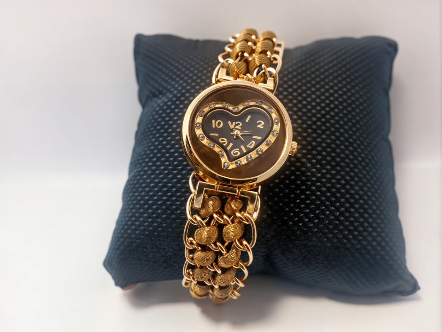 brown bracelet watch on black pillow 