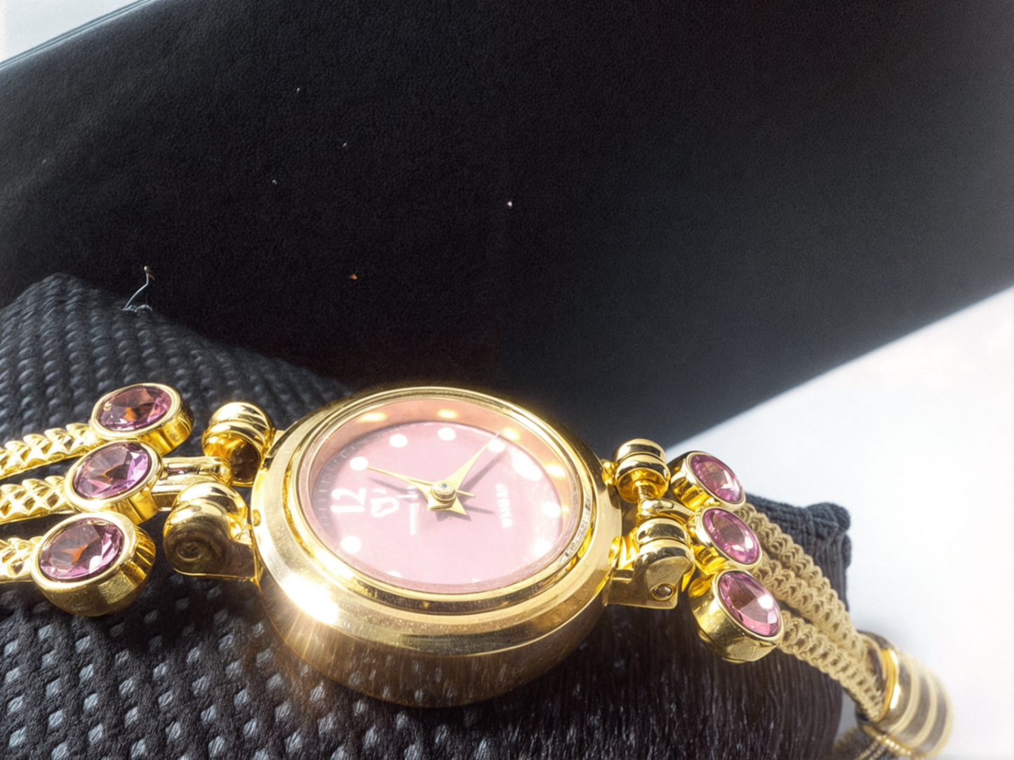pink bracelet watch with black background