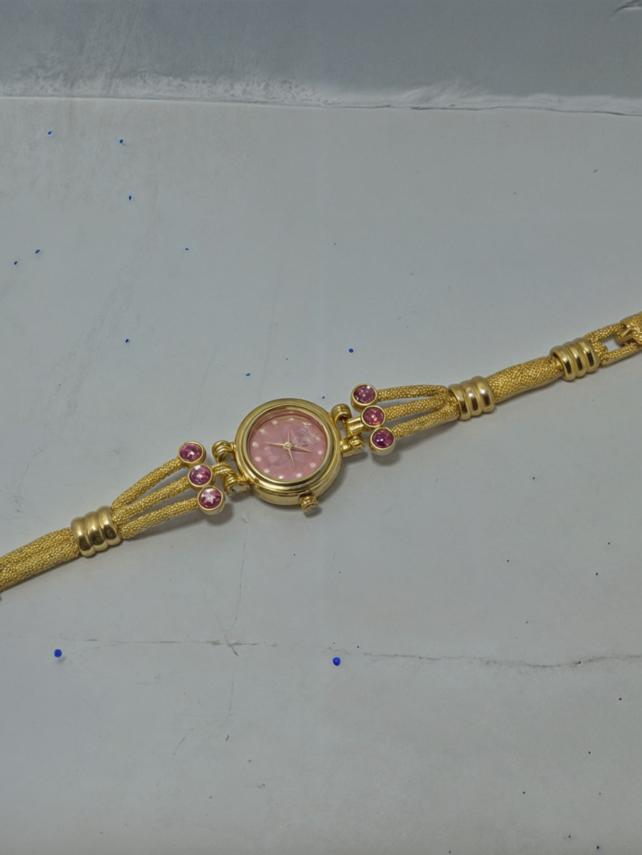 gold color watch for girls on white surface