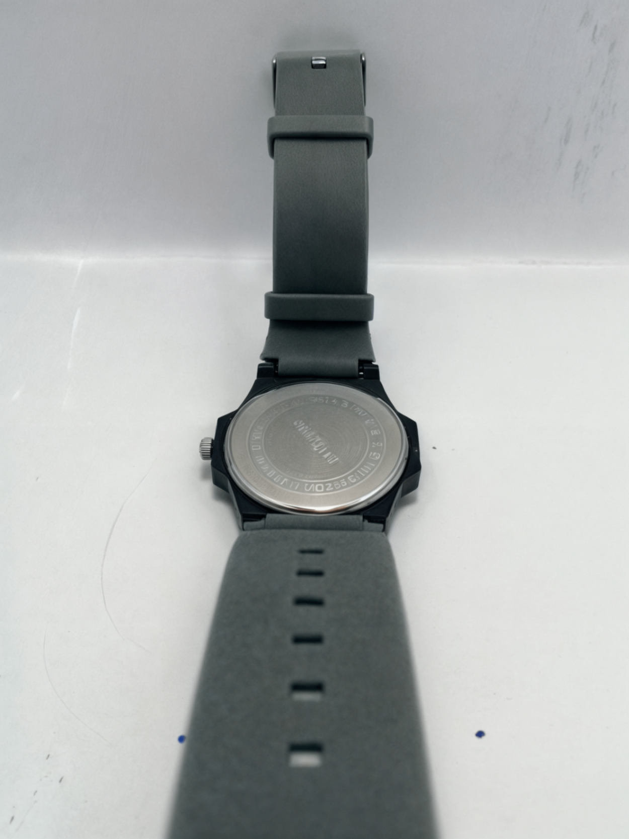 watch with silicon strap on white surface face down