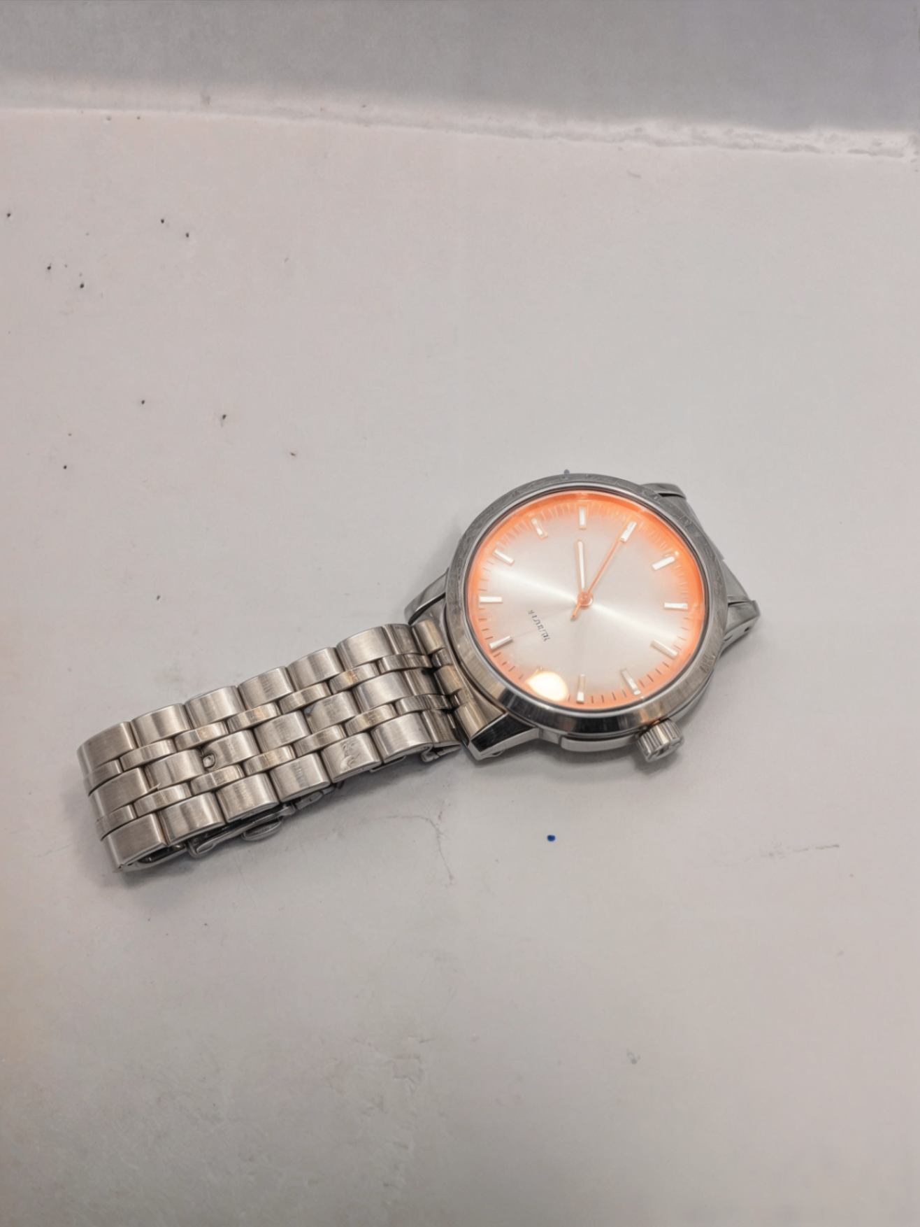 orange watch on white surface